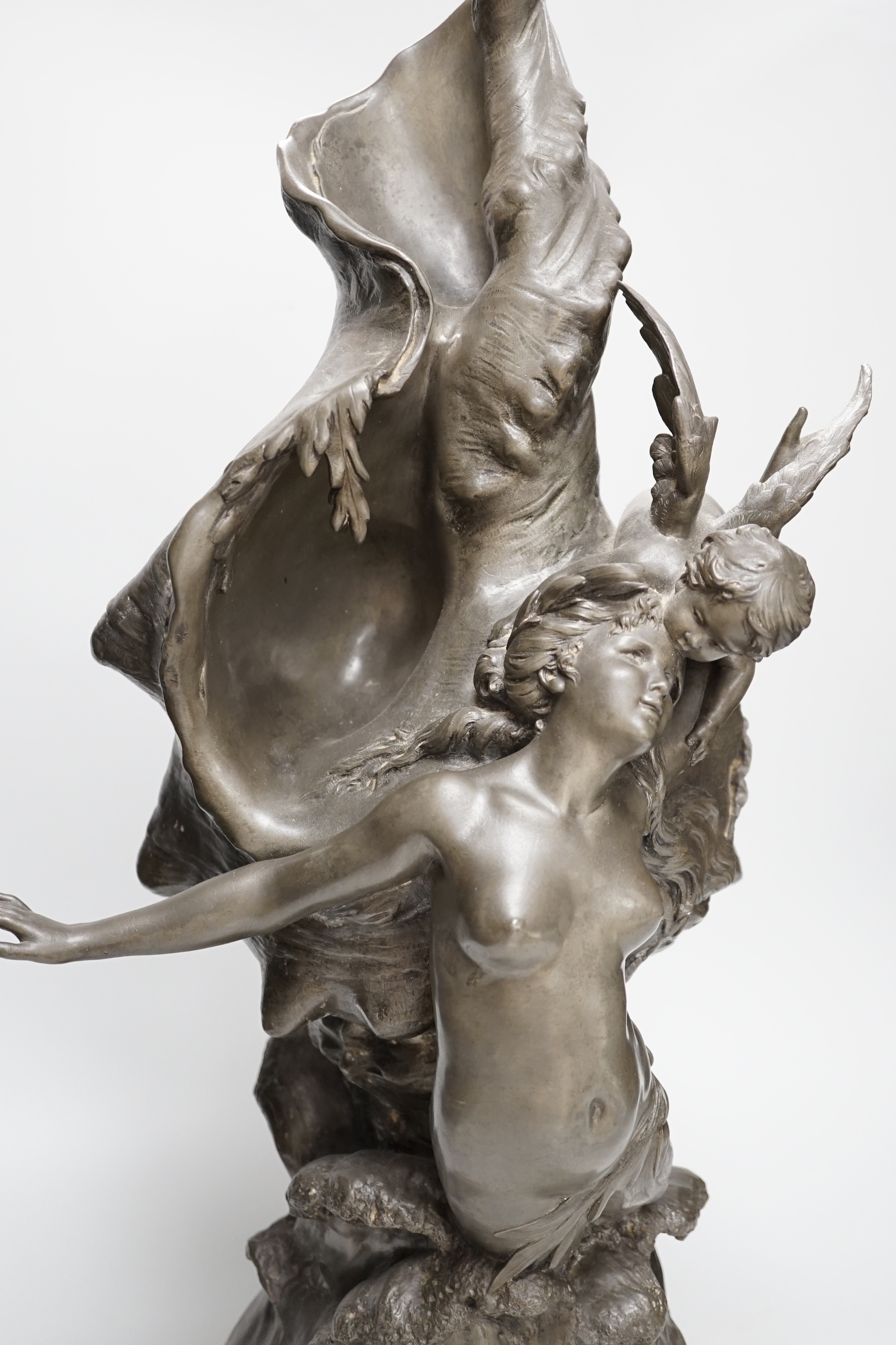 After H. Francois Moreau, a large spelter group of Cupid and a mermaid before a giant conch shell, signed, 64cm high